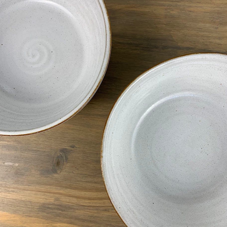 Two ceramic bowls on a wooden surface