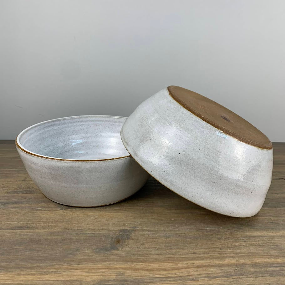 Two wheel thrown bowls. One is upside down and leaning on the other