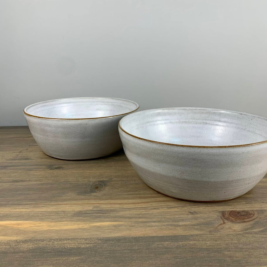 Two ceramic bowls on a wooden surface with a gray background