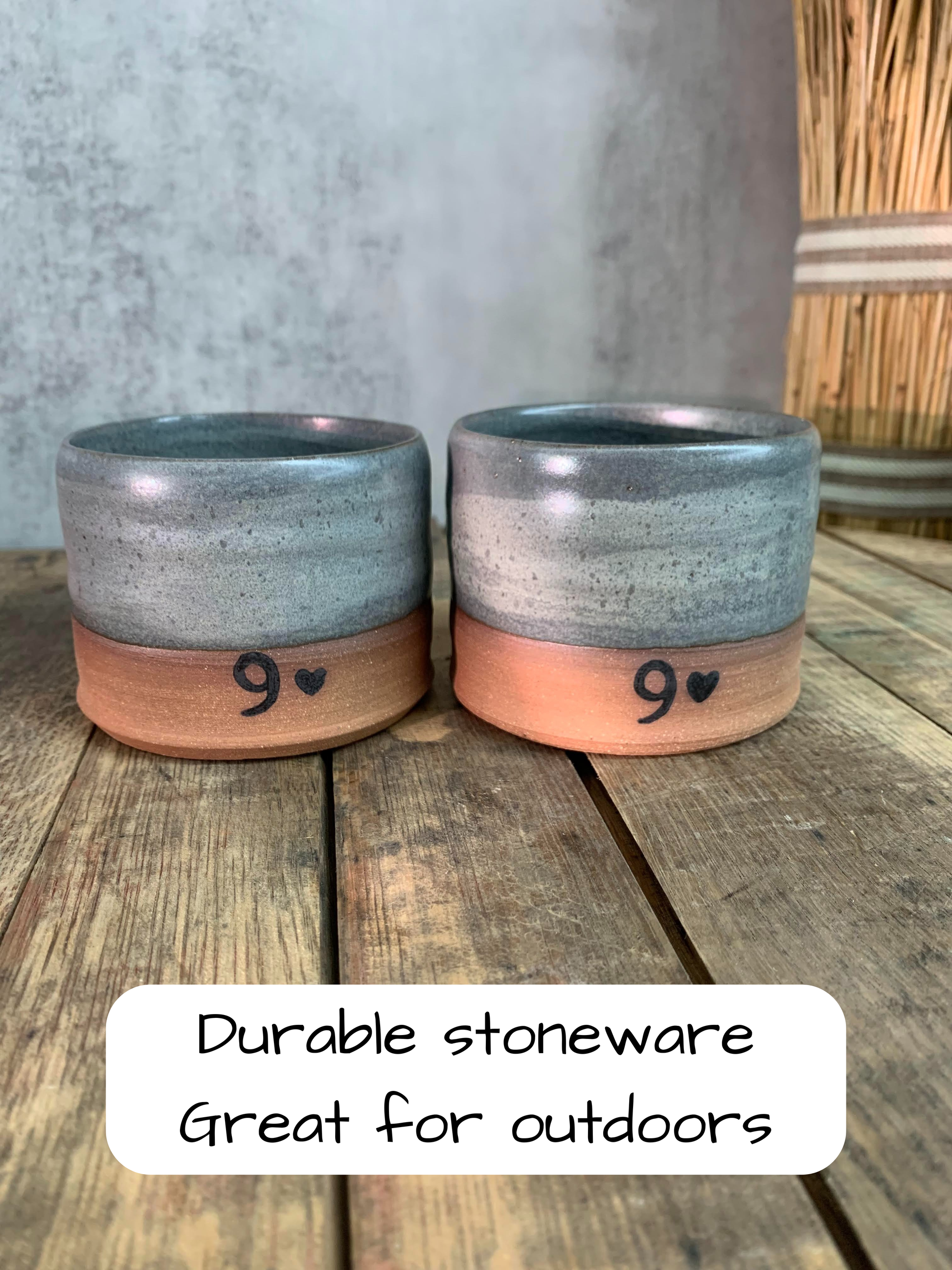 Two durable stoneware pottery lowball glasses with '9' hearts on a wooden surface.