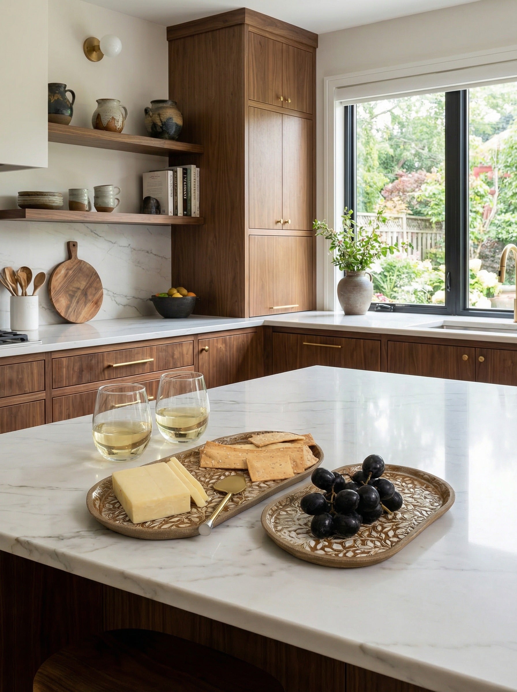 Kitchen with marble island featuring a handcrafted set of serving platters with cheese, bread, and grapes