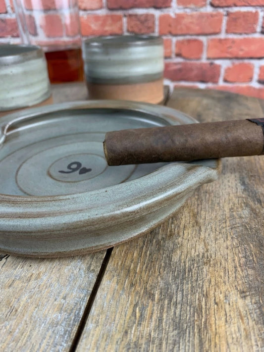 Cigar on a ceramic ashtray with a brick wall background