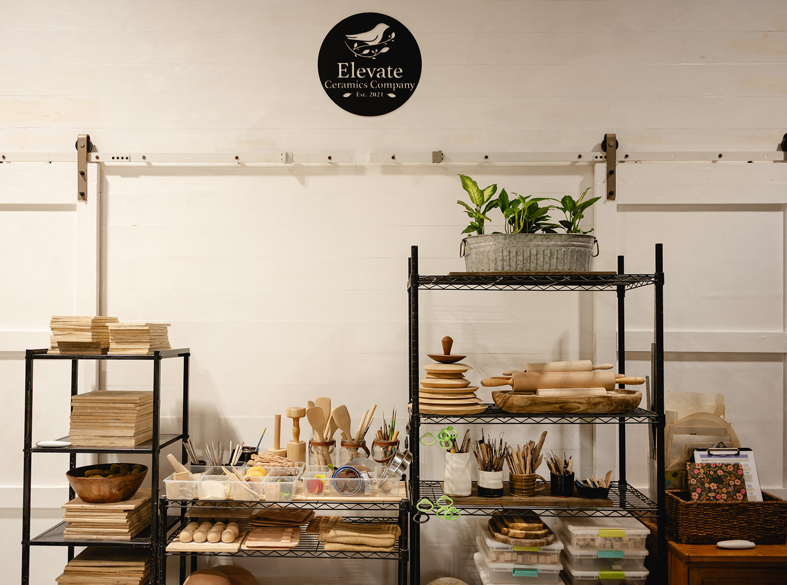 Display of wooden products on shelves with 'Elevate' logo on the wall.