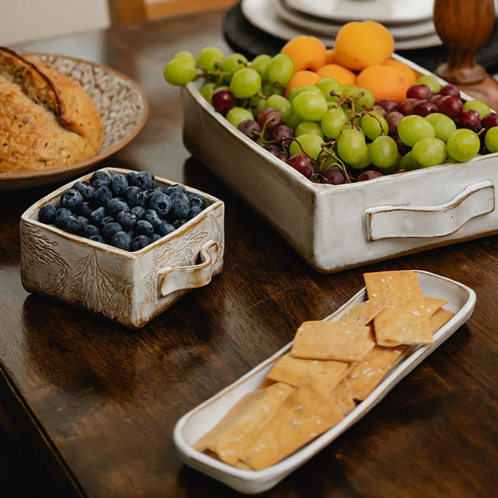 Assorted fruits, bread, and crackers on a wooden table