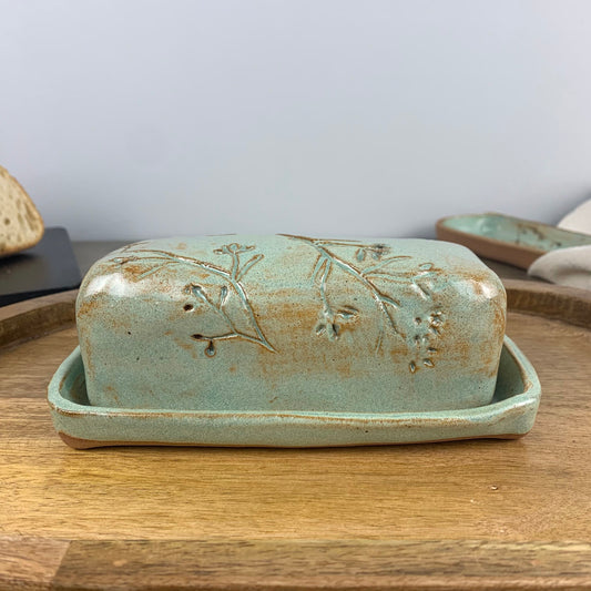 Ceramic butter dish with lid on a wooden surface