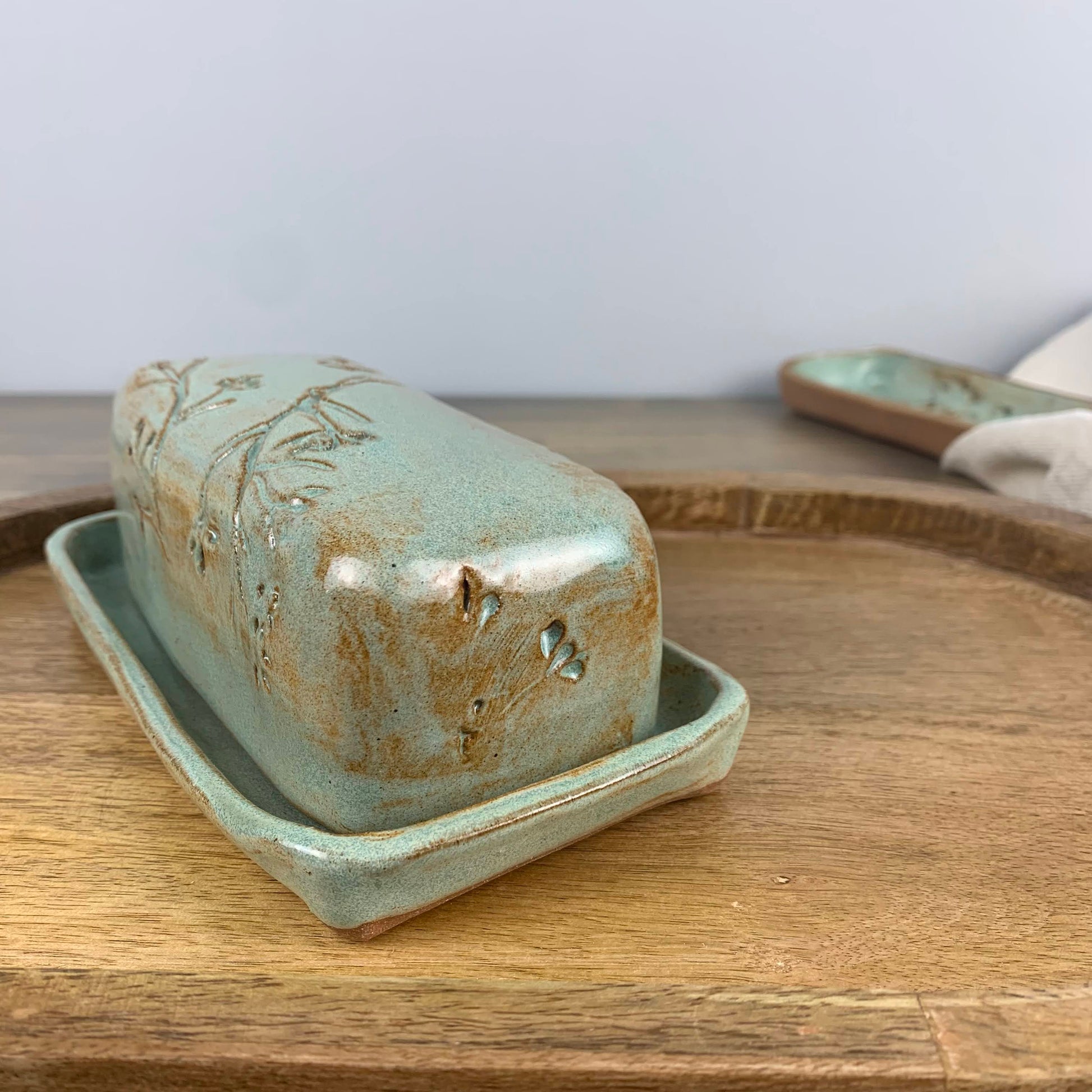 Ceramic butter dish with lid on a wooden surface