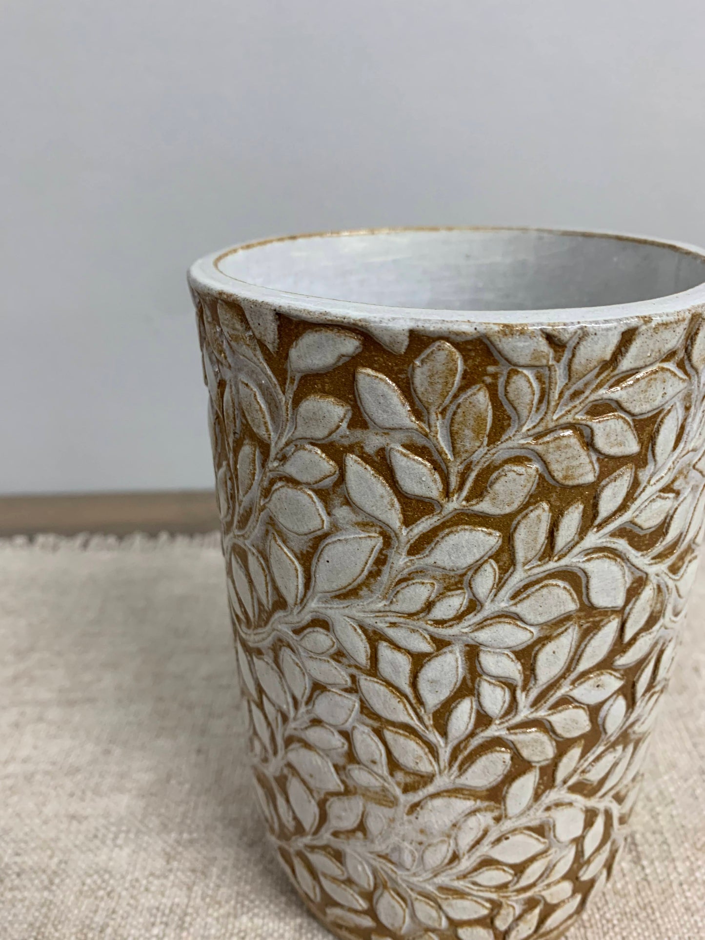 artisan Ceramic vase with leaf pattern on a neutral background