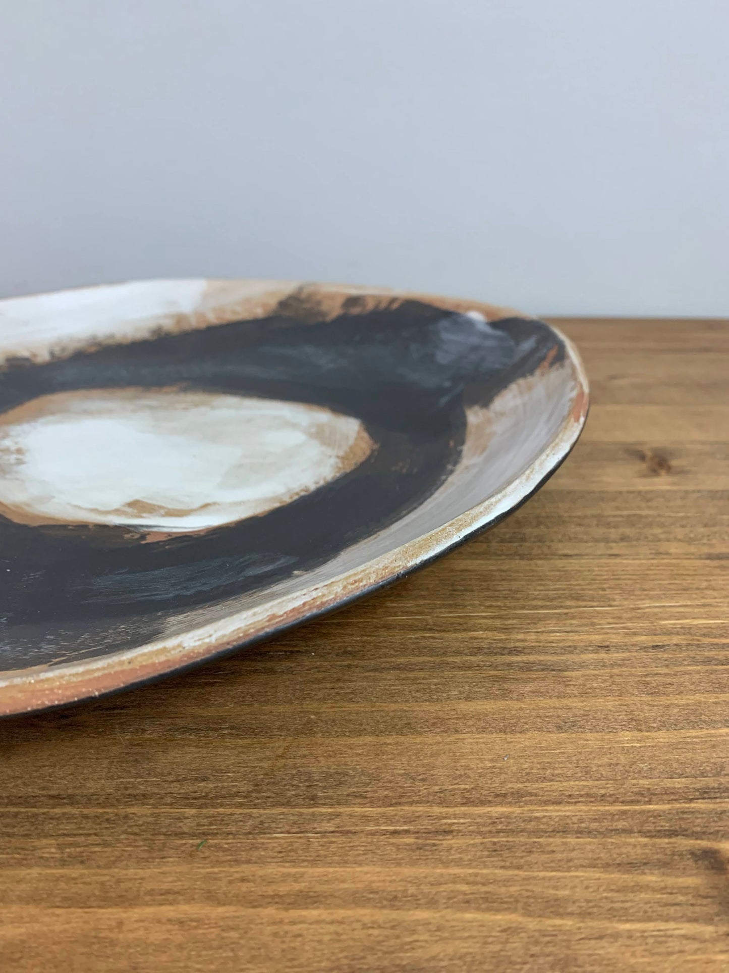Close-up of a ceramic plate with black and white design on a wooden surface