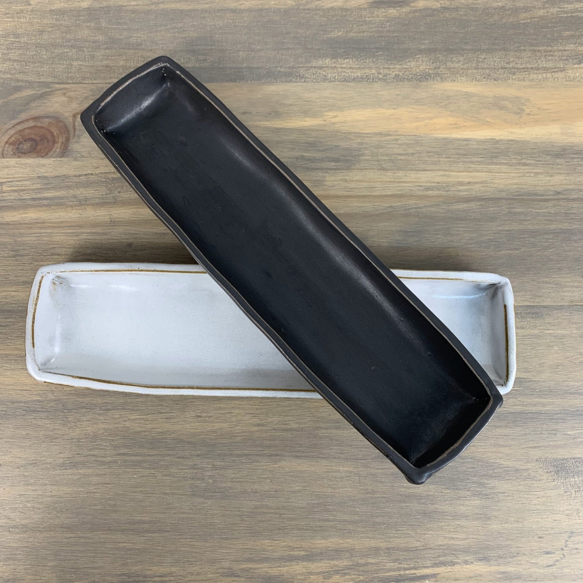 Black rectangular stoneware tray on a wooden surface