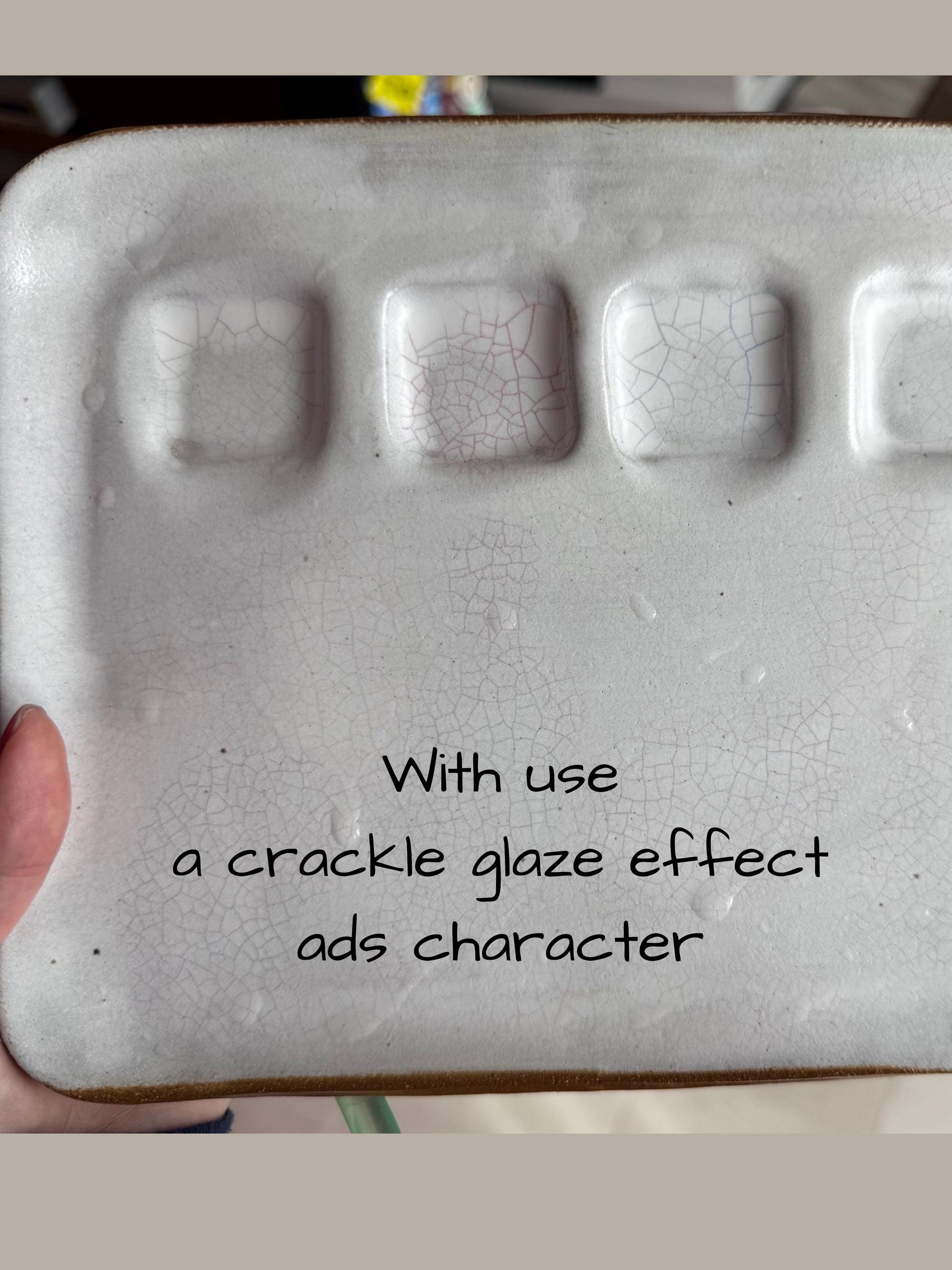 Ceramic paint palette with a crackle glaze effect held by a hand, text overlay on a blurred background.
