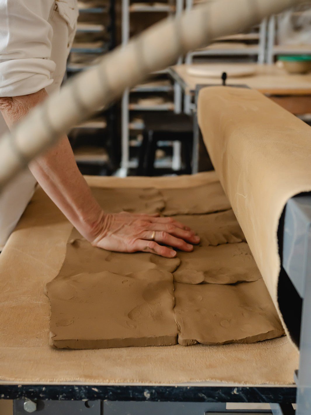 person working with clay in a pottery studio