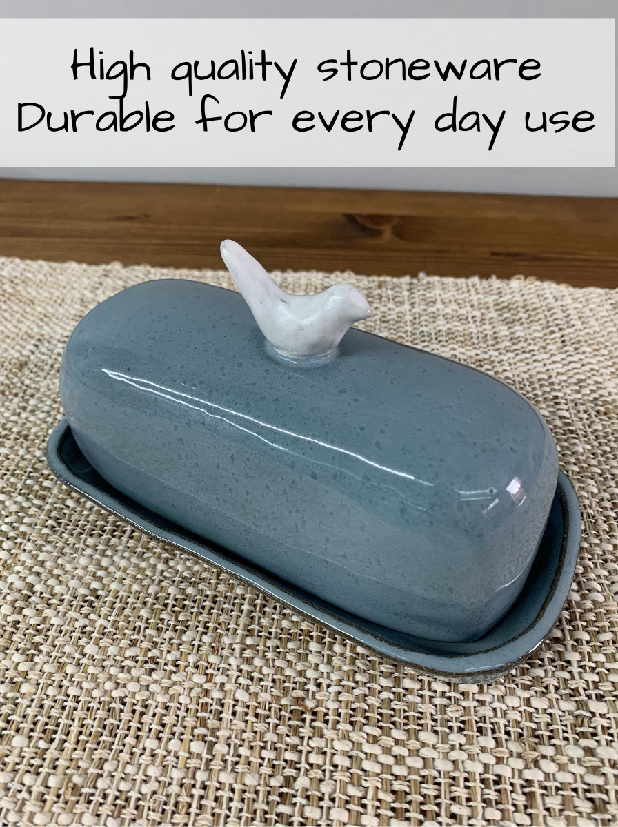 Blue ceramic butter dish with bird design on a woven mat