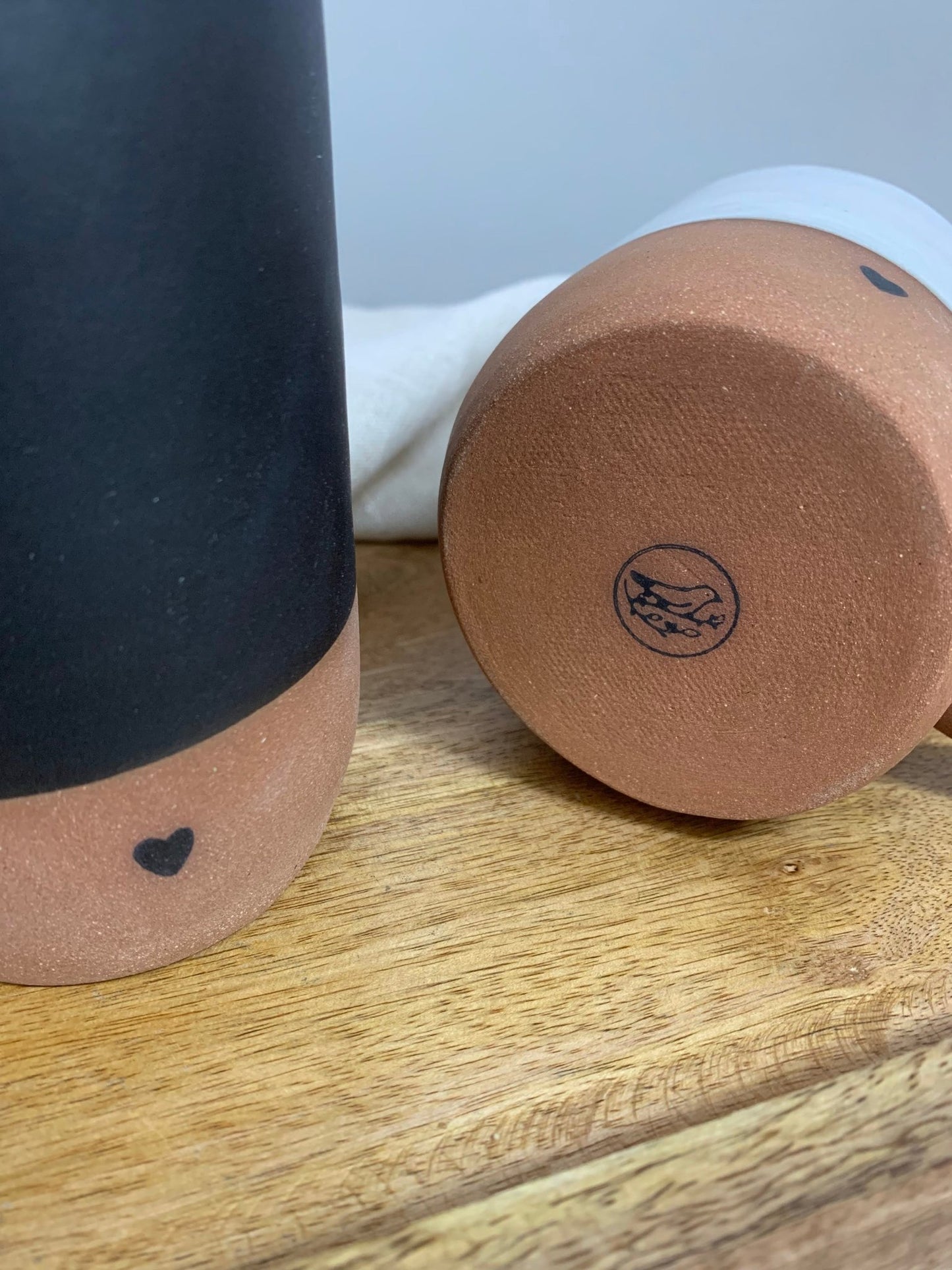 Two ceramic items with heart design on a wooden surface