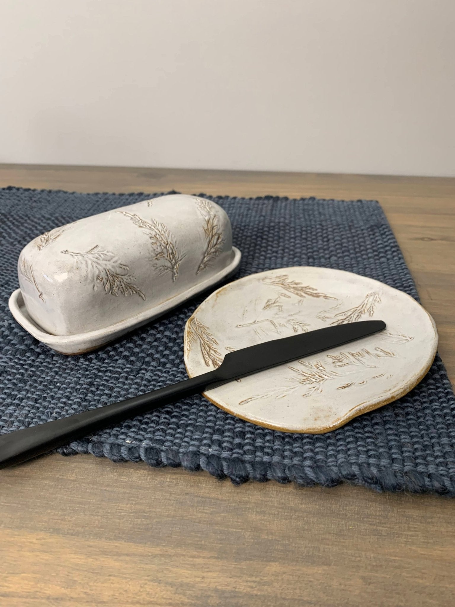 Artisan Butter dish with lid and knife on a blue placemat