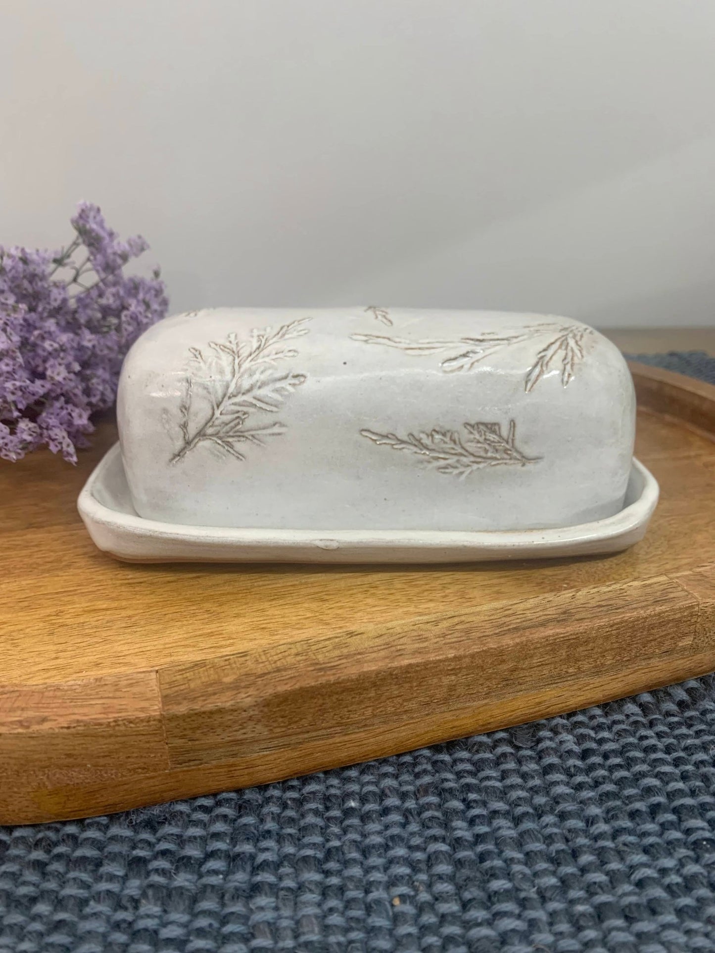 handmade Ceramic butter dish with floral design on a wooden surface