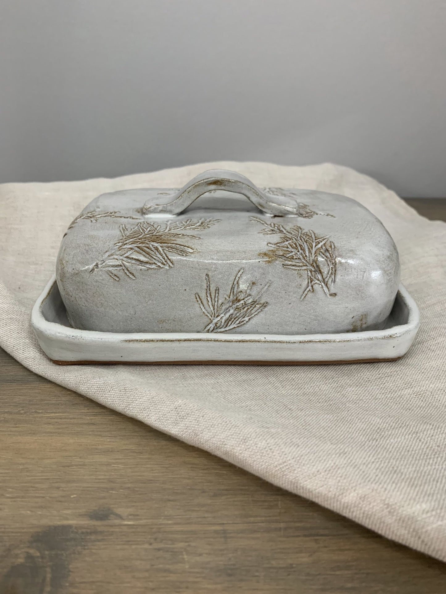 Handcrafted large butter dish with lid on a wooden surface