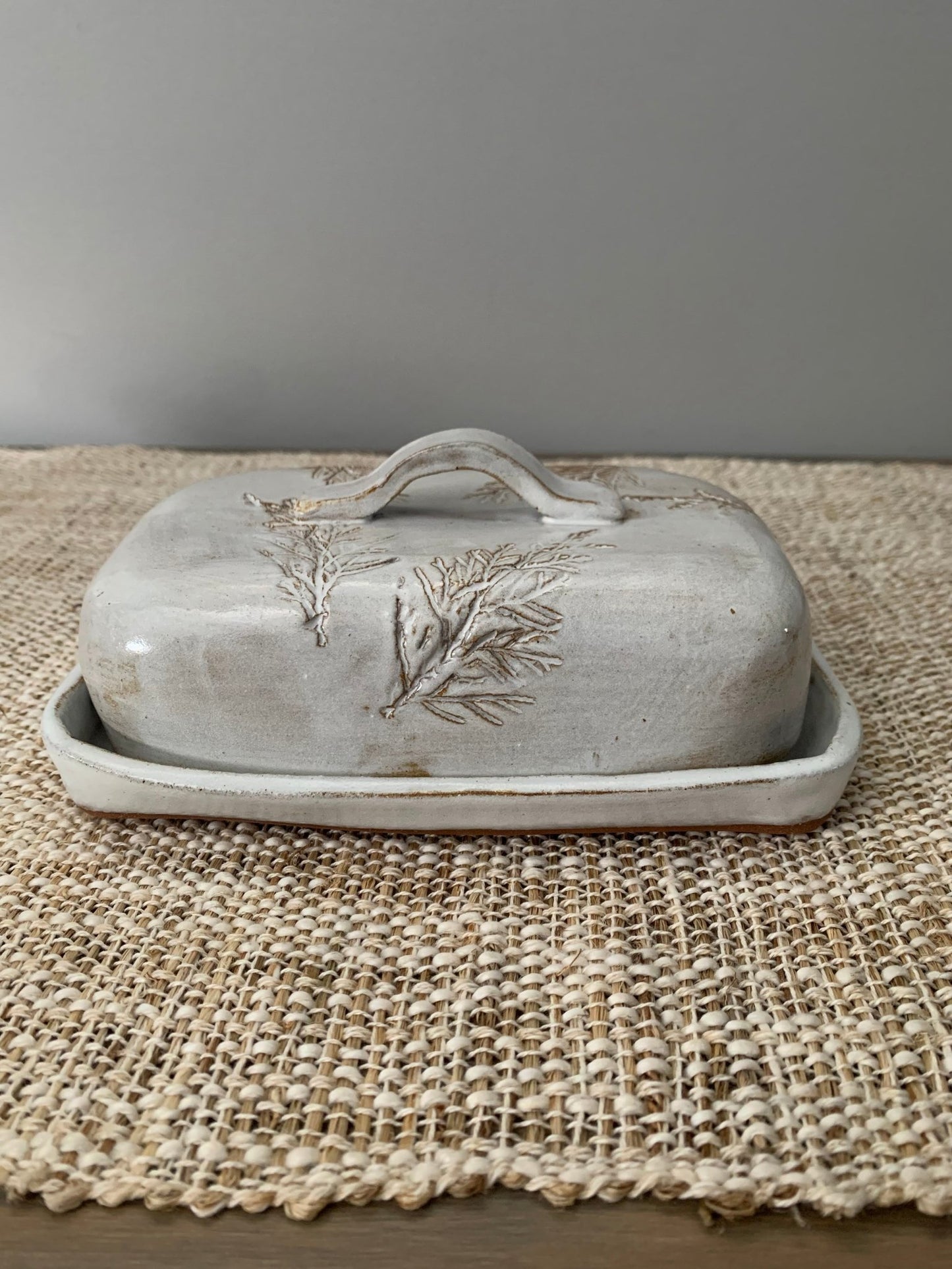 large european size Decorative ceramic butter dish with leaf design on a textured surface