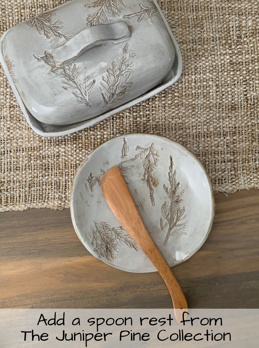 handcrafted Butter dish with wooden spoon on a textured surface, featuring 'The Juniper Pine Collection' text.