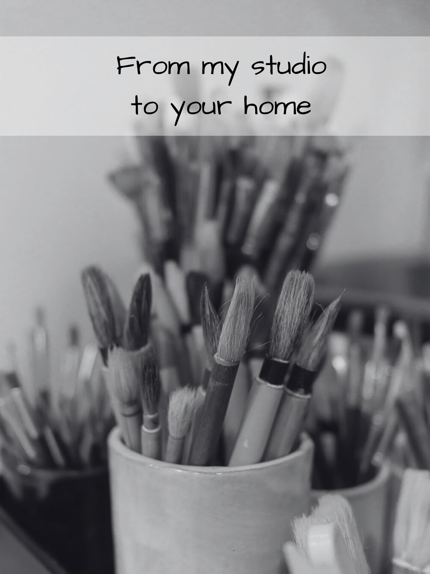 Collection of paintbrushes in a cup with text 'From my studio to your home' on a blurred background.