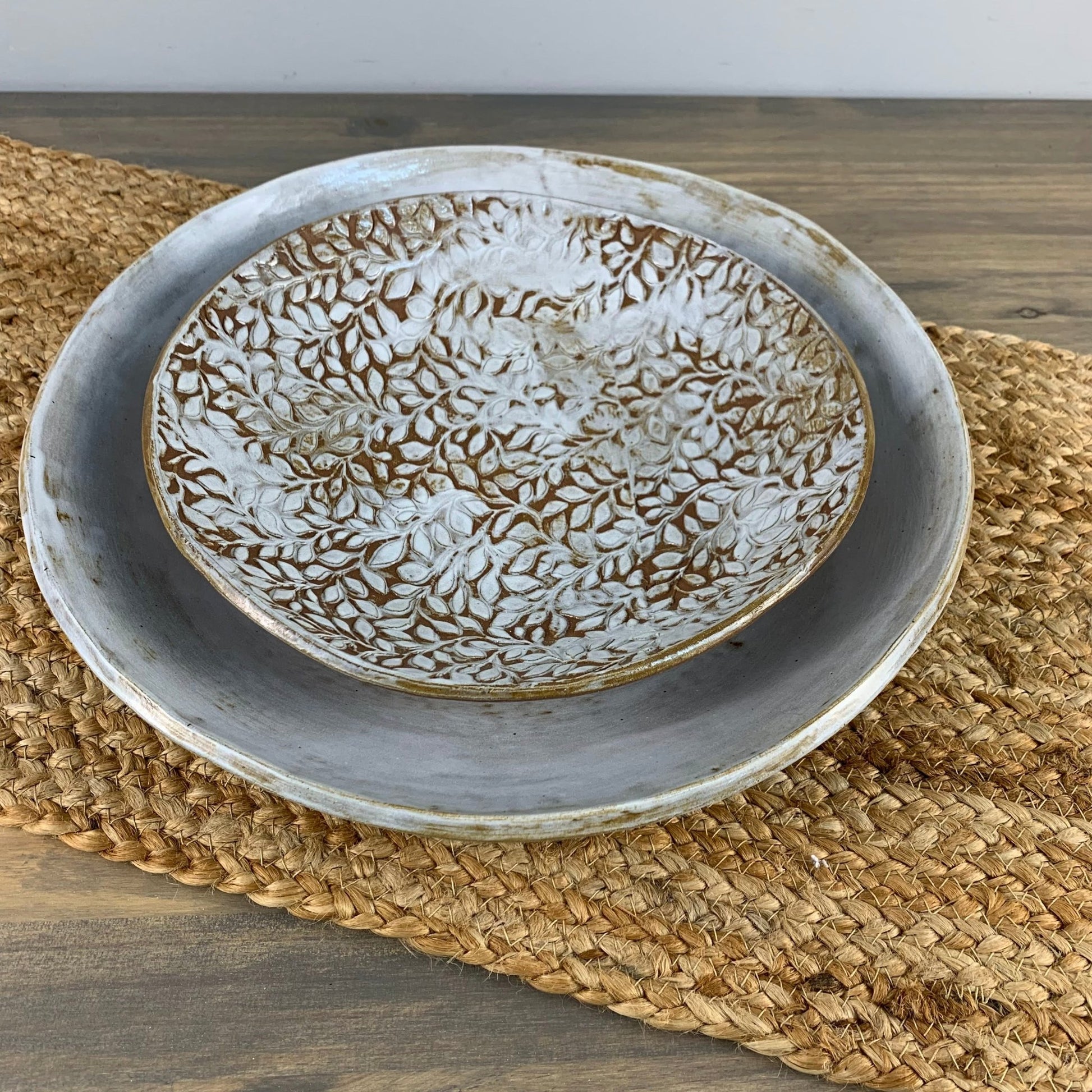 Ceramic dinnerware with textured design on a woven mat