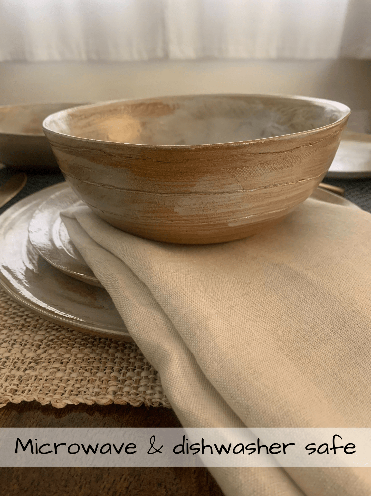 Ceramic bowl on a table with text indicating microwave and dishwasher safety.