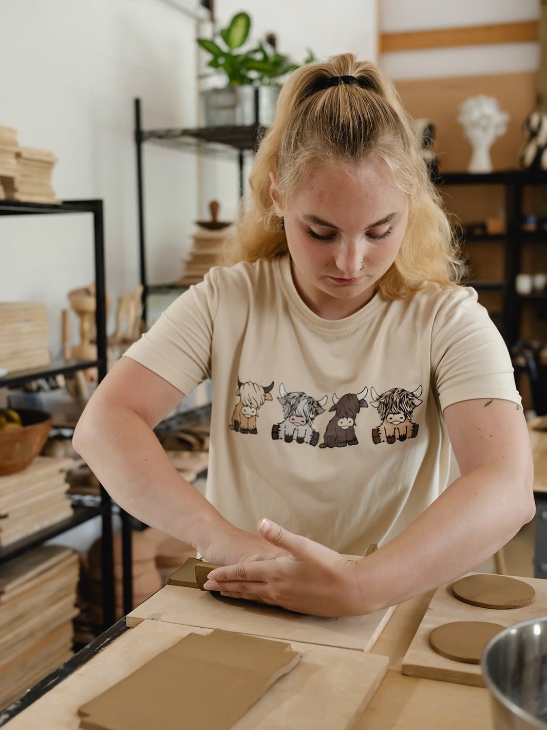 woman using her hands working with clay in a ceramic pottery art studio