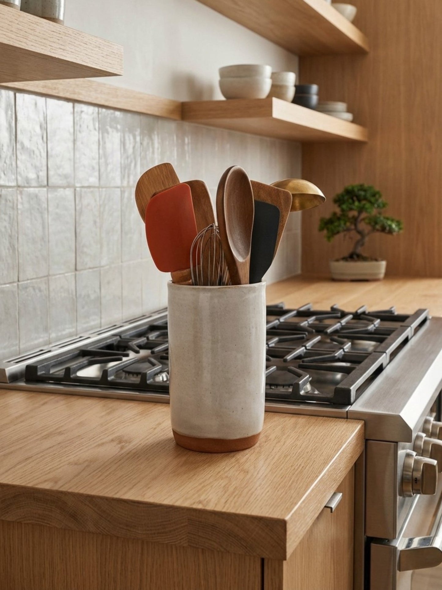 Ceramic utensil holder with wooden utensils on a kitchen counter