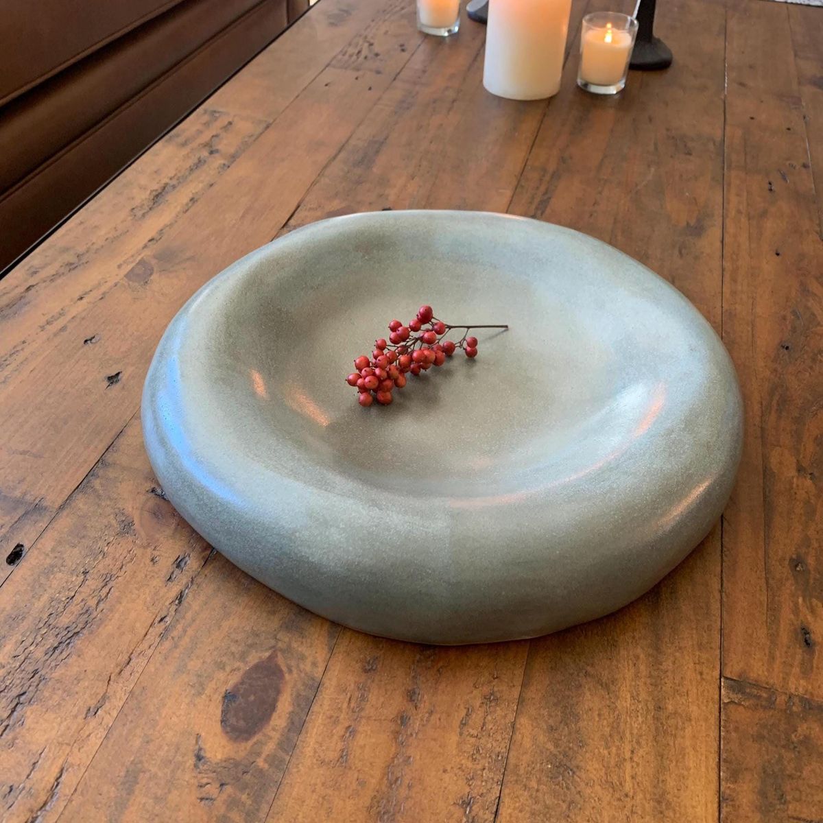 Ceramic bowl with red berries on a wooden table