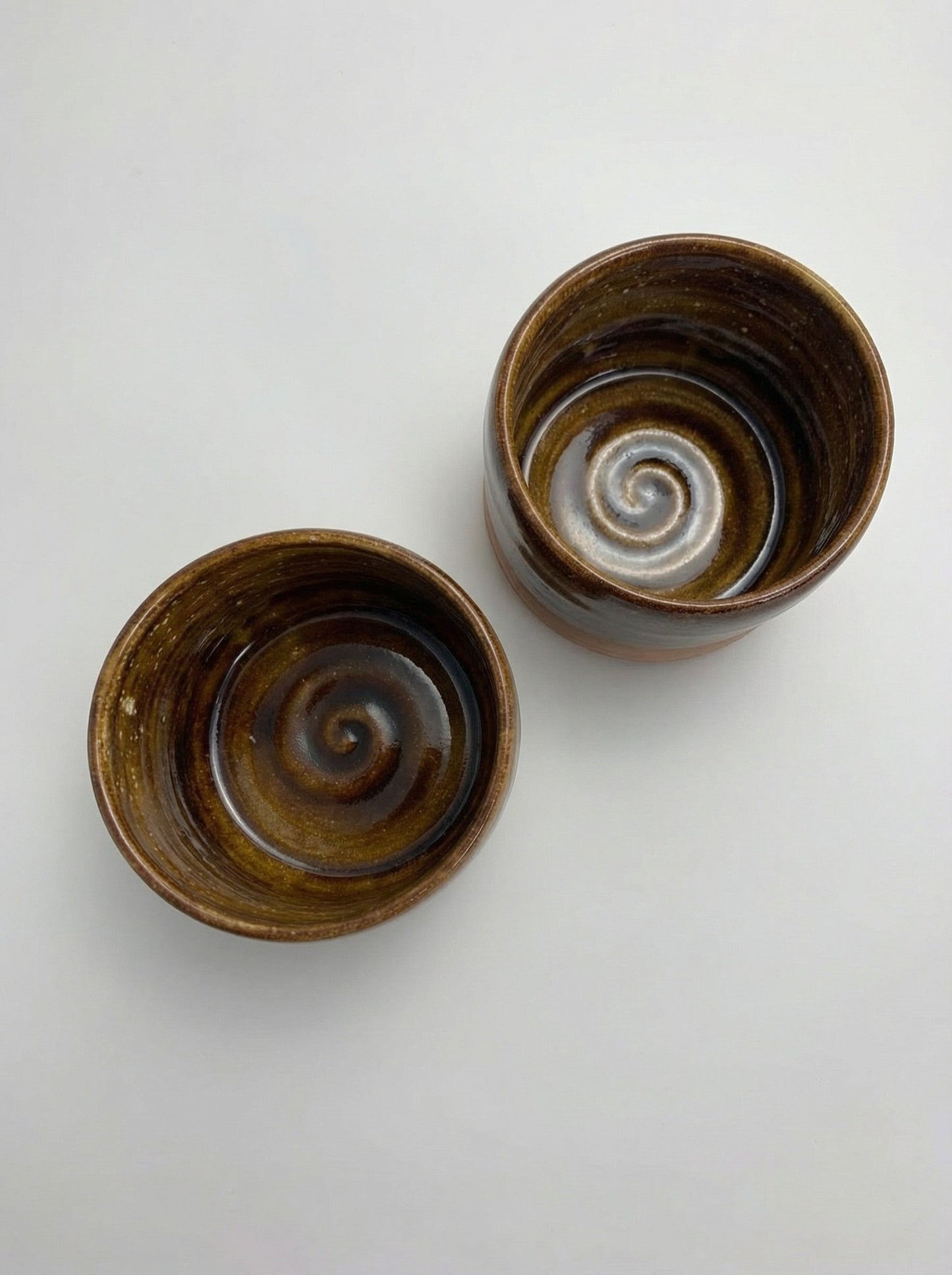 Two ceramic bowls with spiral patterns on a white background