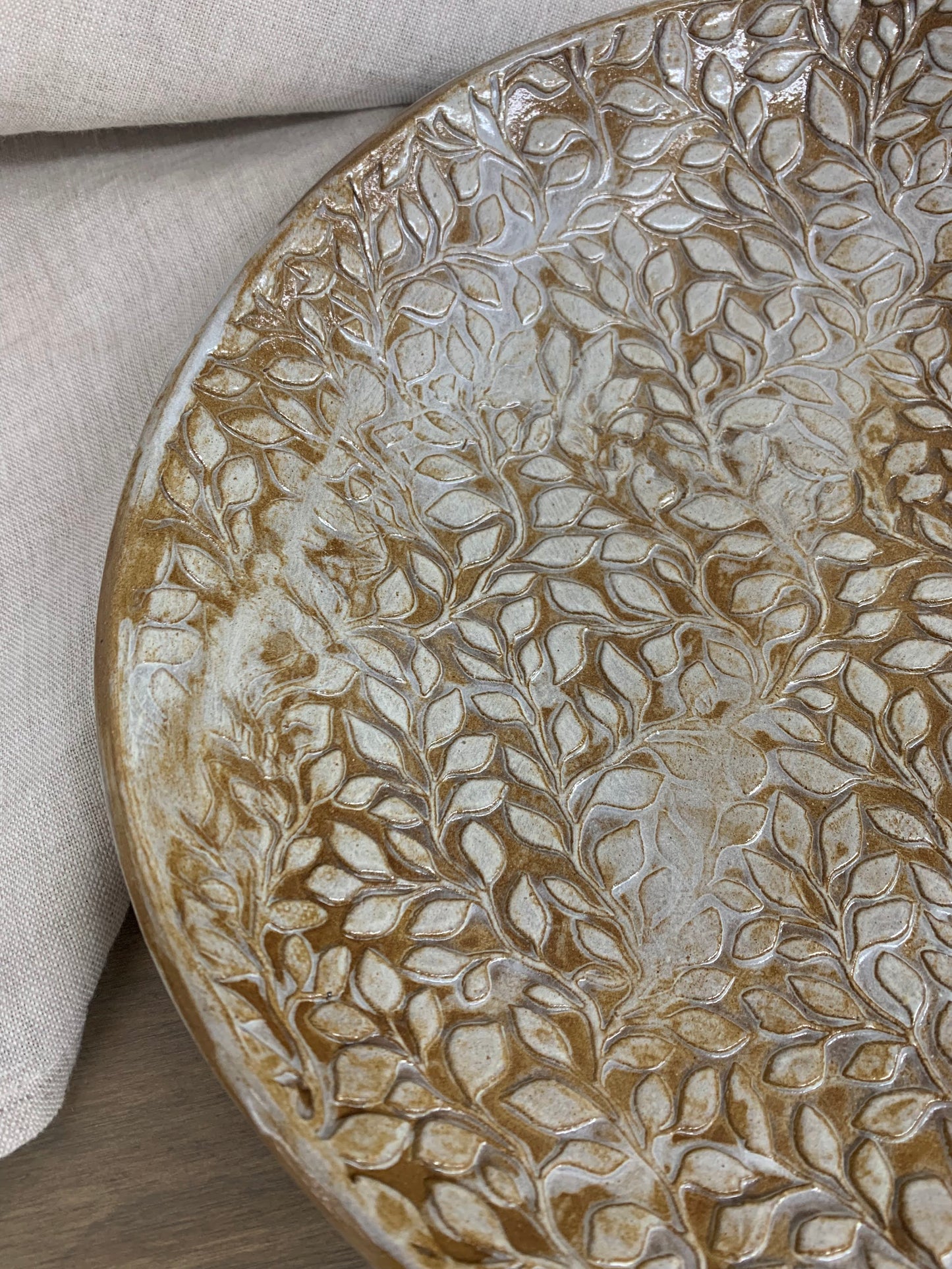 Decorative ceramic bowl with leaf pattern on a neutral background